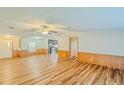 Open living room with wood-look floors and access to kitchen at 408 Garrett Ridge Ct, Winter Haven, FL 33880