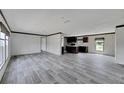 Open concept living room and kitchen with gray plank flooring at 10109 Old Spanish Trl, Polk City, FL 33868