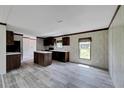 Kitchen features dark brown cabinets, an island, and gray flooring at 10109 Old Spanish Trl, Polk City, FL 33868
