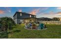 Backyard with firepit and seating area under screened patio at 411 Sunfish Dr, Winter Haven, FL 33881