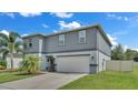 Two story gray house with attached garage and landscaping at 411 Sunfish Dr, Winter Haven, FL 33881