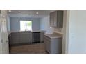 Open kitchen with gray cabinets, stainless steel dishwasher and tile floor at 1412 Swan Ct, Poinciana, FL 34759