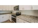 Modern kitchen features granite countertops and stainless steel appliances at 802 Fraser Dr, Poinciana, FL 34759