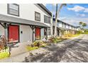 Row of townhouses with red doors and landscaping at 5675 Charleston St # 58, Orlando, FL 32807