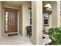 Covered front porch with seating and decorative landscaping at 5240 Oakbourne Ave, Davenport, FL 33837