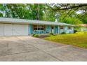 Ranch style home with white double doors garage and landscaped lawn at 6269 Se 125Th Pl, Belleview, FL 34420