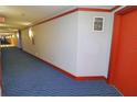 Condo hallway with blue carpet and red doors at 231 Riverside Dr # 2409-1, Holly Hill, FL 32117