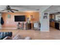 Living room with orange walls, large TV, and view into dining area at 147 Longwood Dr, Ormond Beach, FL 32176
