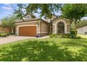 One-story home with a two-car garage and landscaped yard at 3240 Tralee Dr, Ormond Beach, FL 32174