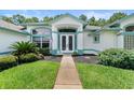 Double-door entry with a walkway and landscaped yard at 1273 Sunningdale Ln, Ormond Beach, FL 32174
