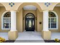 Close-up of house entry with columns, arched doorway, and sun decor at 6218 Cranberry Dr, Port Orange, FL 32127