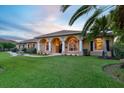 House exterior at dusk with columns, arched entryway, and landscaping at 6218 Cranberry Dr, Port Orange, FL 32127