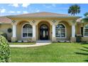 House exterior featuring columns, arched entryway, and landscaping at 6218 Cranberry Dr, Port Orange, FL 32127