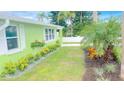 Landscaped side yard with a light green house at 54 Palmetto Dr, Ormond Beach, FL 32176
