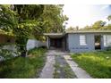 Gray house with carport and overgrown lawn at 809 Maley St, Daytona Beach, FL 32114