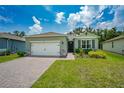 Two-car garage, light grey exterior, and neatly landscaped yard at 1743 Red Rock Rd, New Smyrna Beach, FL 32168