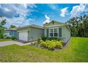 Two-car garage, light green exterior, and neatly landscaped yard at 1743 Red Rock Rd, New Smyrna Beach, FL 32168