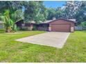 Ranch style home with a large driveway and mature landscaping at 1119 Indigo Rd, Ormond Beach, FL 32174