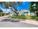 Single story home with light blue exterior, a brick driveway and a large oak tree at 309 Sears Ave, Daytona Beach, FL 32118