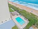Aerial view of condo complex pool area, beach, and ocean at 1513 Ocean Shore Blvd # 6C, Ormond Beach, FL 32176