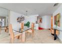 Modern dining room featuring glass table, stylish chairs, and unique wall decor at 2545 S Atlantic Ave # 1701, Daytona Beach Shores, FL 32118