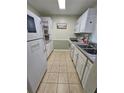 Full view of kitchen with white cabinets, tile floors, and stainless steel appliances at 1510 Ocean Shore Blvd # 4140, Ormond Beach, FL 32176