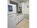 White kitchen cabinets, tile floors, and stainless steel appliances at 1510 Ocean Shore Blvd # 4140, Ormond Beach, FL 32176