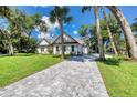 Beautiful home with a paved driveway, lush lawn, and mature trees at 10 Whitehall Ct, Flagler Beach, FL 32136