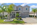 Two-story home with gray siding, landscaping, and paver driveway at 137 Azure Mist Way, Daytona Beach, FL 32124