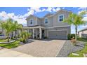 Two-story home with gray siding, landscaping, and paver driveway at 137 Azure Mist Way, Daytona Beach, FL 32124