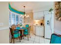 Kitchen breakfast nook with white cabinets and teal chairs at 4565 S Atlantic Ave # 5308, Port Orange, FL 32127