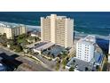 Aerial view of beachfront high-rise building with parking and ocean views at 89 S Atlantic Ave # 1002, Ormond Beach, FL 32176