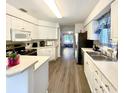 Galley-style kitchen with white cabinets and an island at 129 Blue Heron Dr # A, Daytona Beach, FL 32119