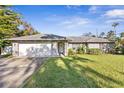 Brick house with a two-car garage and mature trees at 203 N Duss St, New Smyrna Beach, FL 32168