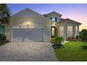 Two-story house with two-car garage, landscaping, and paver driveway at 374 Lost Shaker Way, Daytona Beach, FL 32124