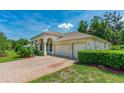 Home features a brick paver driveway and two-car garage at 21 Old Canyon Ln, Ormond Beach, FL 32174