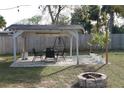 Relaxing patio area with seating, fire pit, and a pergola at 1114 Berkshire Rd, Daytona Beach, FL 32117