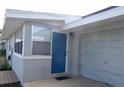 House exterior featuring a blue door and attached garage at 1114 Berkshire Rd, Daytona Beach, FL 32117