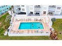 Community pool with lounge chairs and surrounding landscape at 1183 Ocean Shore Blvd # 6040, Ormond Beach, FL 32176