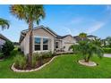 Single-story home with palm trees, manicured lawn, and stone accents at 597 Mosaic Blvd, Daytona Beach, FL 32124