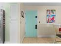 Light teal door entryway with decorative panels and beach themed artwork at 1415 Ocean Shore Blvd # B030, Ormond Beach, FL 32176