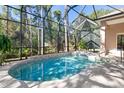 Kidney-shaped pool with a screened enclosure and spa at 3404 Rexford Cir, Ormond Beach, FL 32174