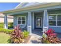 Front porch with white columns and colorful landscaping at 1321 Tullamore Blvd, Ormond Beach, FL 32174