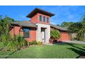Two-story house with reddish exterior, stone accents, and lush landscaping at 660 Aldenham Ln, Ormond Beach, FL 32174