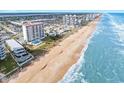 Stunning aerial view of the coastline, showcasing pristine beaches and oceanfront buildings at 1183 Ocean Shore Blvd # 1040, Ormond Beach, FL 32176