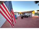 Spacious backyard patio with outdoor dining area and an American flag at 21 Sunset Blvd, Ormond Beach, FL 32176