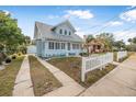 Inviting light blue beach house with a paved driveway and white picket fence at 318 Vermont Ave, Daytona Beach, FL 32118