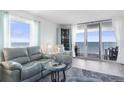 Living room with ocean view, gray couch, and glass top table at 89 S Atlantic Ave # 1401, Ormond Beach, FL 32176