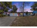 Updated single story home with red front door at dusk at 1703 Hill St, Edgewater, FL 32132