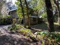 House nestled among mature trees, showcasing a long driveway at 2436 Cr 416N, Lake Panasoffkee, FL 33538